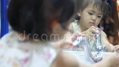 小亚洲女孩喜欢自己<strong>打开水</strong>龙头和洗手